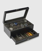The TAWBURY Bayswater 12 Slot Watch Box with Storage in Black/Charcoal is elegantly crafted from PU leather, showcasing up to 12 watches through its glass lid, with a drawer below for straps and essentials.